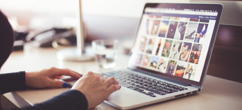 A photograph of a woman's hands as she works on her laptop.