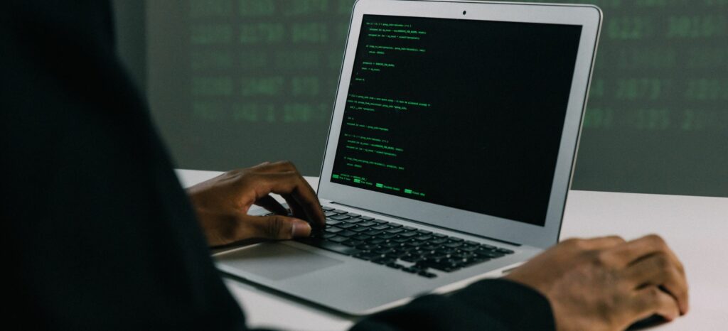A man types code into his laptop