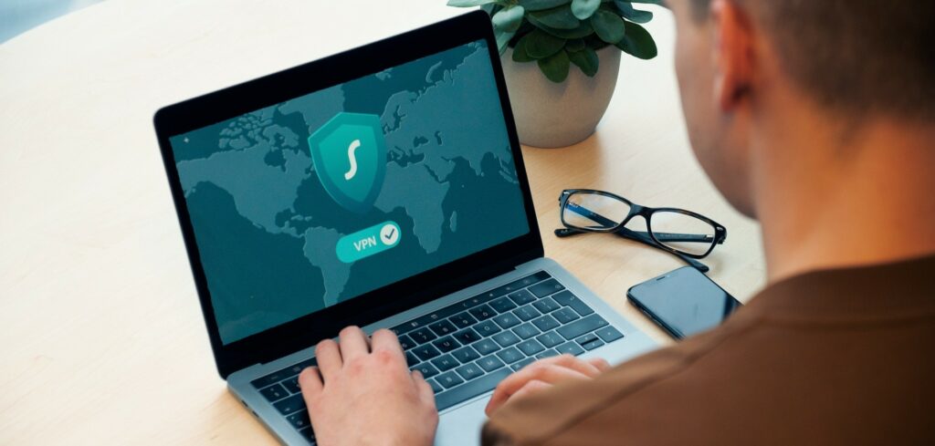 A man types on a laptop with the word, "VPN" on the screen.
