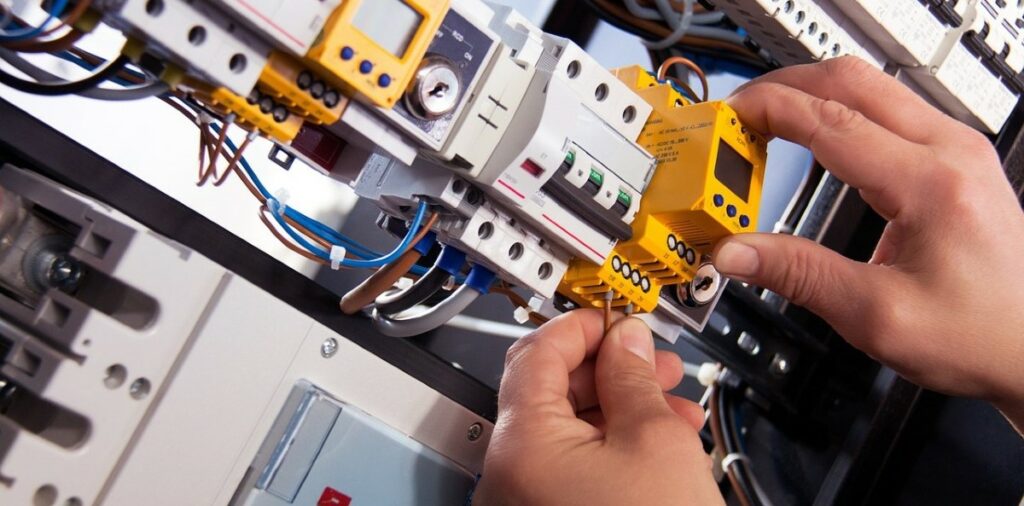 A photograph of someone's hands repairing a piece of computer equipment.