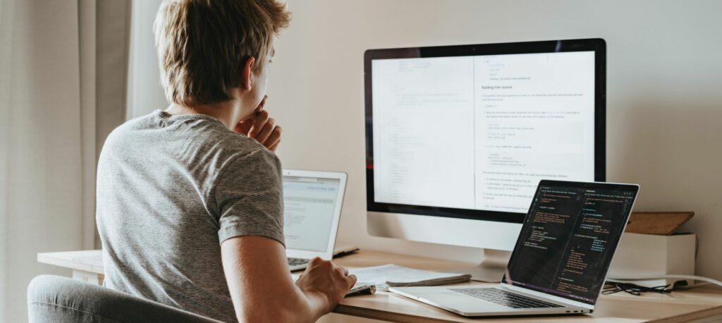 A photograph of a young man working on a computer.